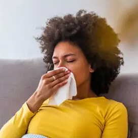 A woman blowing her nose