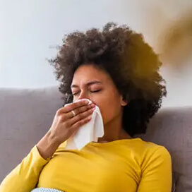 A woman blowing her nose