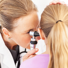 A doctor looking in a child's ear